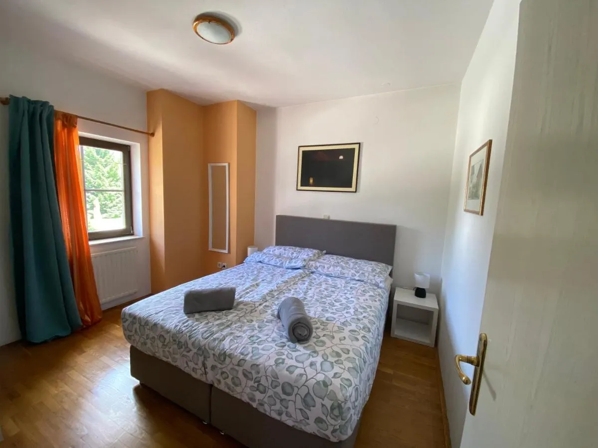 Spalnica z zakonsko posteljo, nočno omarico in oknom