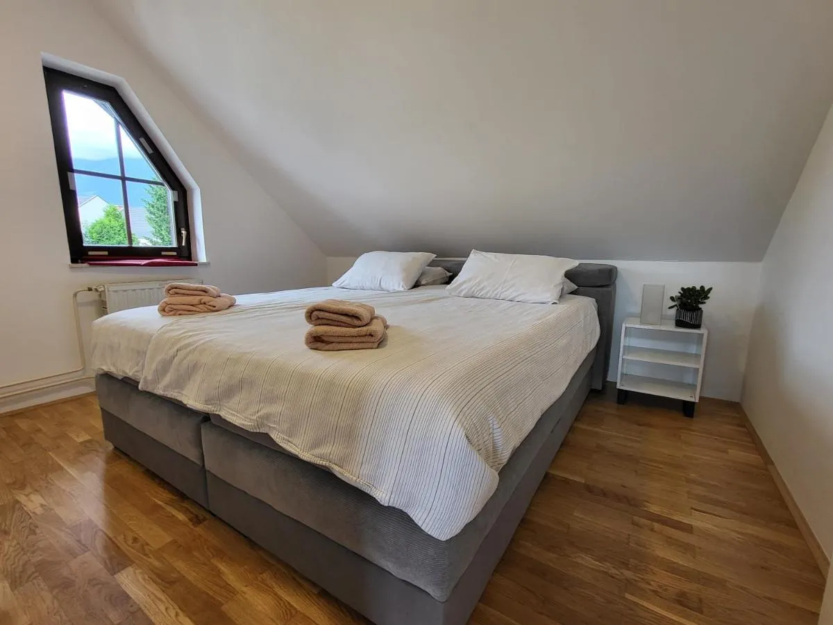 Spalnica z zelo veliko zakonsko posteljo pod poševnim oknom