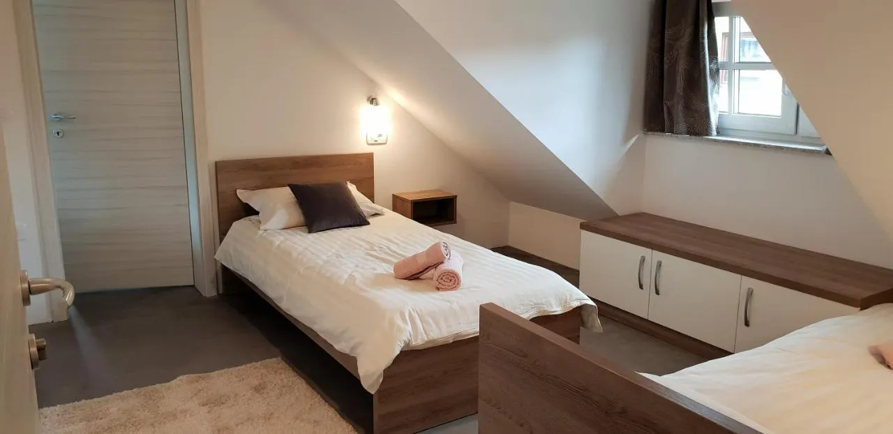 Postelja pod poševnim stropom ob strešnem oknu in vgradne omare