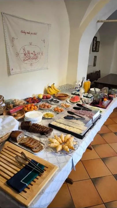 Samopostrežna miza z narezki, siri, sadjem in pecivom pod obokom
